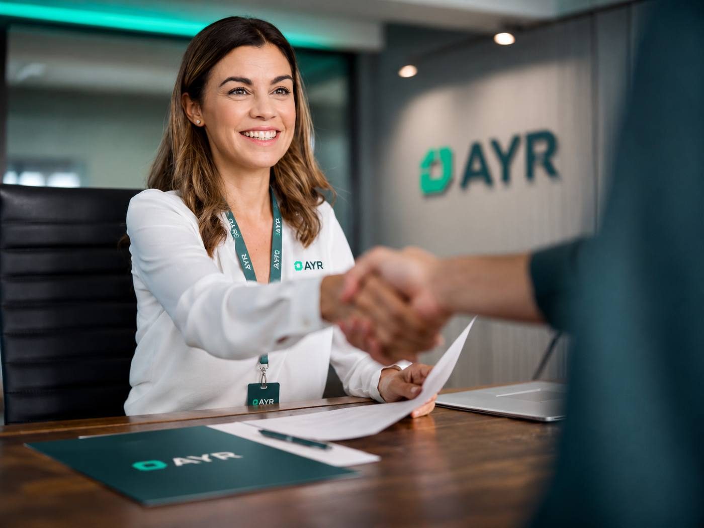 Profesional de AYR dando la mano a una nueva incorporación en la oficina